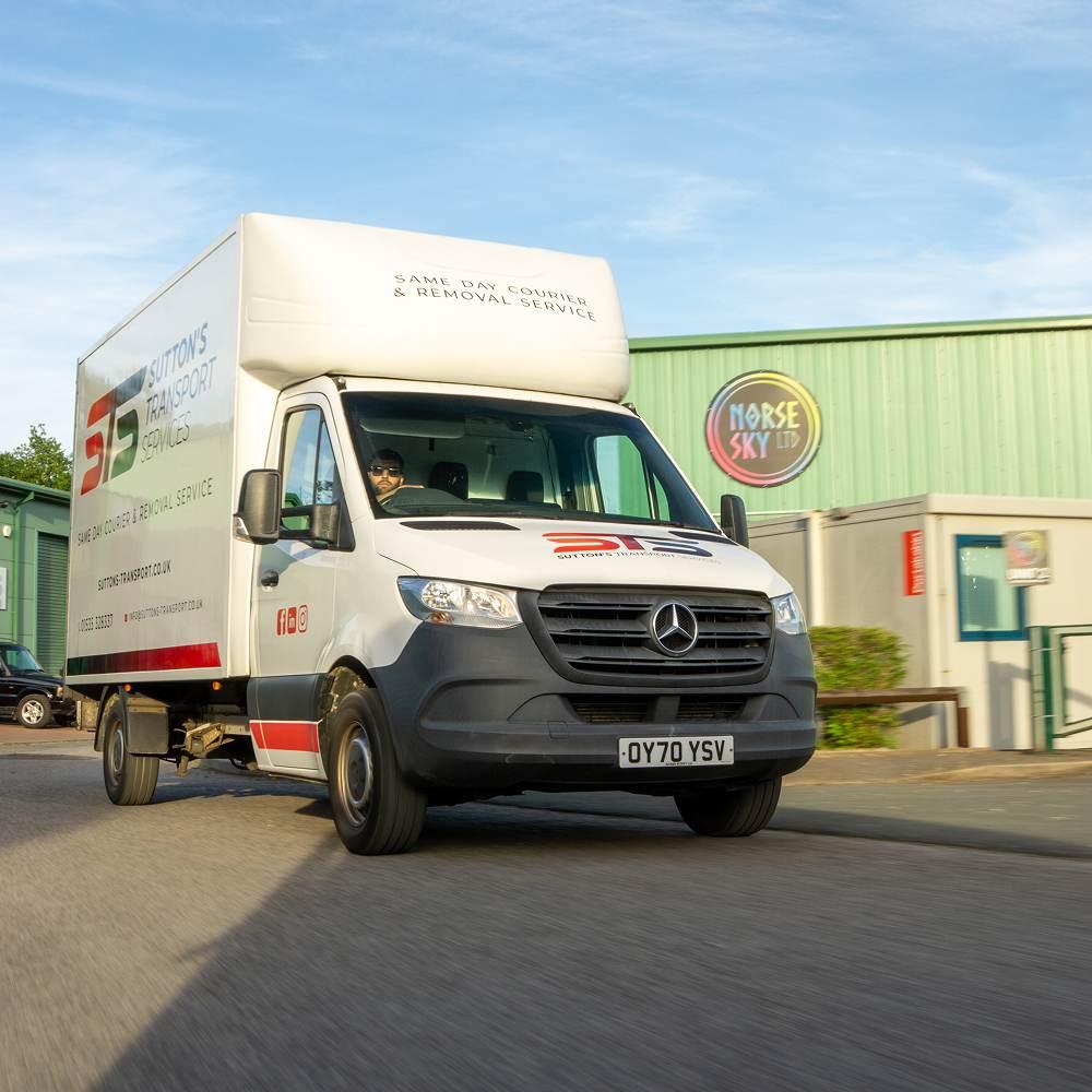 Branded Luton van from the front whilst driving