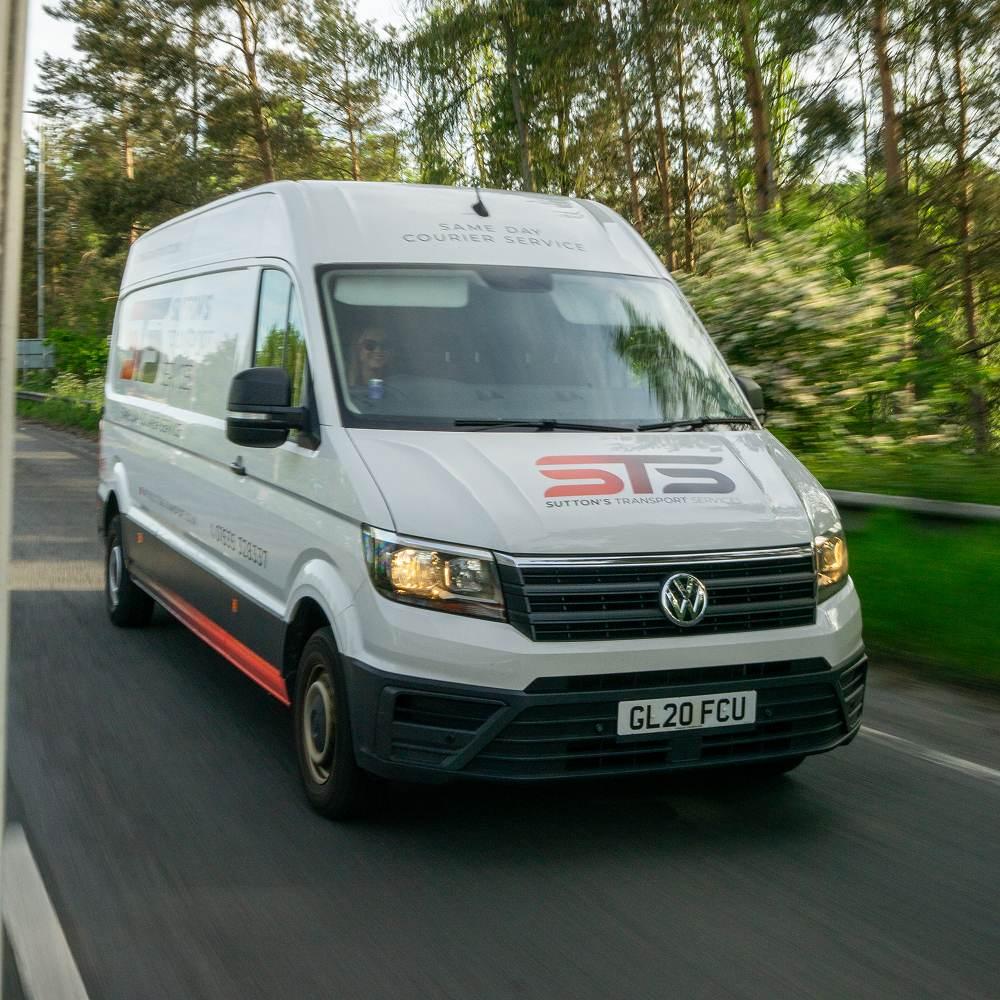 Branded van driving on the road from the front
