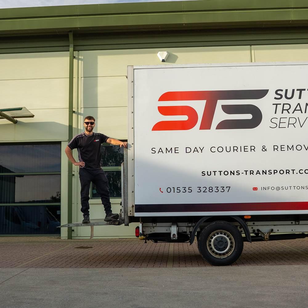 Man stood on tail lift of braned luton van